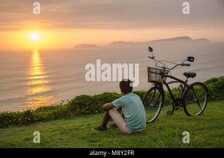 Garçon avec son vélo et de repos face à la mer Banque D'Images