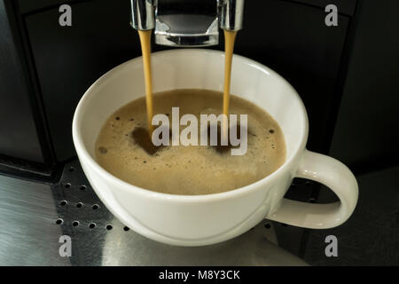 Machine à café expresso est versé dans une tasse blanche à partir de la machine à café Banque D'Images