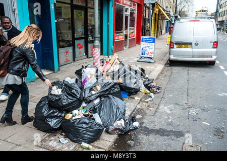 Un tas d'ordures sacs noirs entassés sur un trottoir à Lambeth Londres. Banque D'Images