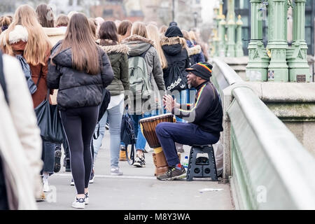 Un artiste de rue sur un tambour djembé de Westminster Bridge à Londres. Banque D'Images