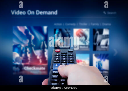 Service de VOD l'écran avec la télécommande en main. La vidéo sur demande télévision internet stream concept multimédia Banque D'Images