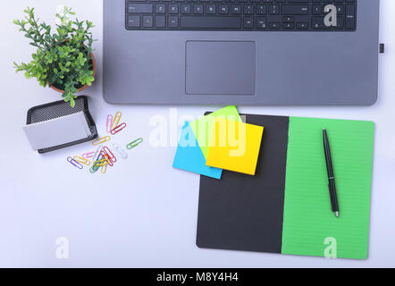 Close-up of confortable espace de travail au bureau avec ordinateur portable, portable, lunettes, stylo et autres équipements portant sur table avec copie espace. Vue d'en haut. Banque D'Images