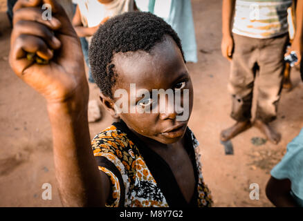 Un enfant de couleur africaine demande de l'aide comme il est dépeint à regarder attentivement l'objectif de la caméra, dans un village près de Watamu, Kenya, Africa Banque D'Images