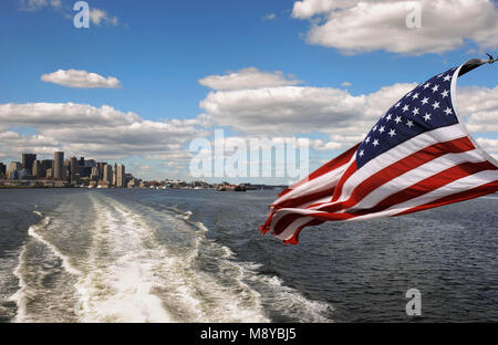 Les Stars and Stripes drapeau des États-Unis d'Amérique aux commandes de l'arrière d'un traversier rapide avec le Boston skyline en arrière-plan Banque D'Images