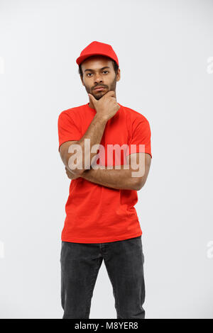 Concept de livraison - Handsome African American man bras croisés plus isolé sur fond studio gris. Copier l'espace. Banque D'Images