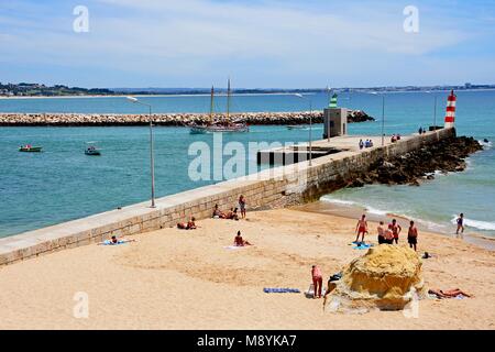 Les touristes se détendre sur la plage de Praia da Batata auprès des vacanciers sur les bateaux à l'arrière, Lagos, Algarve, Portugal, Europe. Banque D'Images