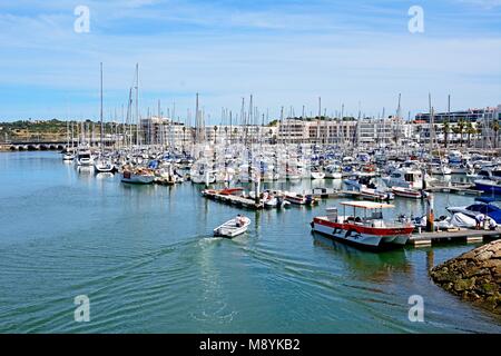 Vue sur les bateaux et yachts amarrés dans le port de plaisance de Lagos avec les personnes bénéficiant de l'établissement, Lagos, Algarve, Portugal, Europe. Banque D'Images