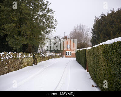 Une allée menant à une maison de campagne en brique dans la neige Banque D'Images