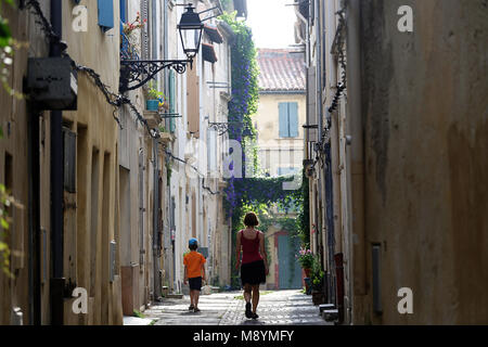 La mère et le fils marchant sur la rue pittoresque, scène de rue à Arles, Provence, France Banque D'Images