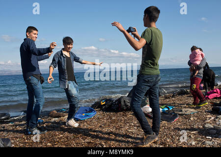 Demandeurs d'asile afghans la danse pour jouer de la musique sur leur téléphone mobile, à célébrer leur arrivée à bon port après avoir traversé la mer Égée. En 2015 plus d'un million d'immigrants sont arrivés en Europe par la mer. Les immigrants sont principalement les réfugiés qui fuient la guerre en Syrie. Banque D'Images