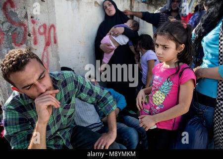 Un Palestinian-Syrian frustré attend de la famille sous le soleil chaud à l'extérieur du camp de la Moria pour demandeurs d'asile et migrants, après avoir été informés qu'ils devraient passer à un autre site. De l'autre site, on leur a dit qu'ils doivent retourner à la Moria site. En 2015 plus d'un million d'immigrants sont arrivés en Europe par la mer. Les immigrants sont principalement les réfugiés qui fuient la guerre en Syrie. Banque D'Images