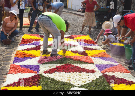 Antigua, Guatemala : le 18 mars 2018 : les habitants travaillant sur alfombres, tapis de fleurs avec des fleurs et de l'eau tube sur les rues pavées de la procession Banque D'Images