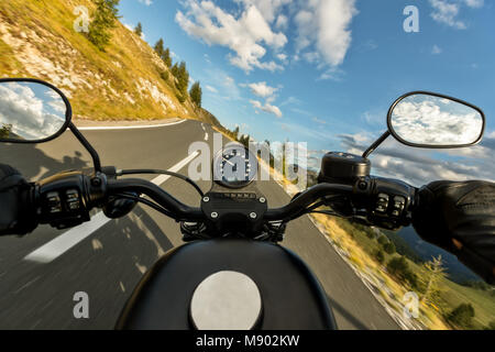 POV de motorbiker maintenant le bar, équitation dans Alpes en beau coucher du soleil Ciel dramatique. Et la liberté de déplacement, activités en plein air Banque D'Images