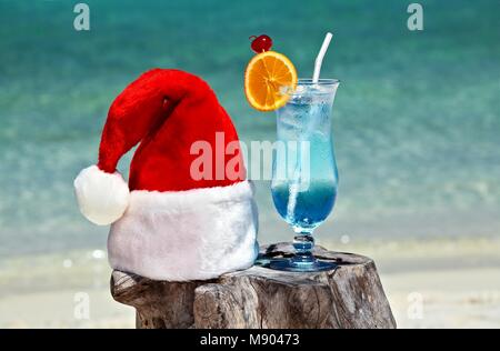 Bocal d'eau tonique est sur la plage d'origine le tableau est fait de tronc d'arbre avec Santa hat Banque D'Images