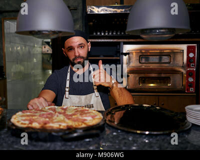 Cuire la pizza mâle Banque D'Images
