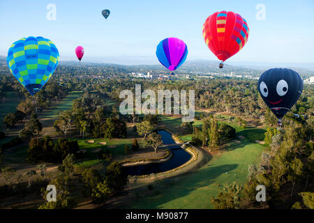 Couleur lumineuse montgolfières survolant Golf fédéral de Canberra avec Red Hill en arrière-plan, participant à hot air balloon festival Banque D'Images