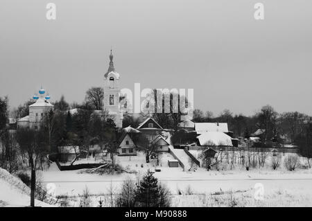 Vue sur une petite rivière sur un village avec église couverte de neige sur une sombre journée d'hiver, rivière Nerl Porechye, village, région de Tver, Russie Banque D'Images