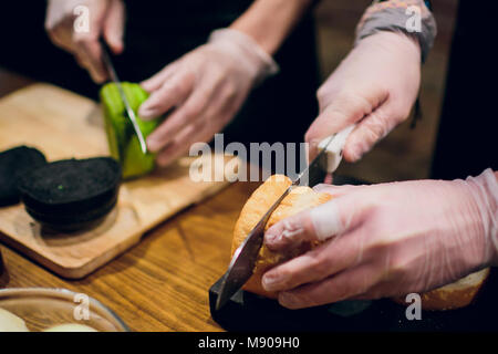 Le cuisinier en chef préparation des burger dans la cuisine.Burger Restaurant menu processus de cuisson. Le cuire un chignon sur l'arrière-plan d'autres ingrédients. F Banque D'Images