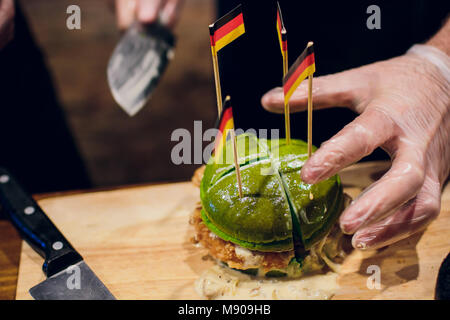 Le cuisinier en chef préparation des burger dans la cuisine.Burger Restaurant menu processus de cuisson. Le cuire un chignon sur l'arrière-plan d'autres ingrédients. F Banque D'Images