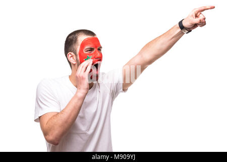 Bel homme supporter fan de l'équipe nationale du Maroc drapeau peint get happy face crier victoire fait main. Fans d'émotions. Banque D'Images