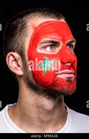 Portrait de bel homme partisan face fan de l'équipe nationale du Maroc avec drapeau peint isolé face sur fond noir. Banque D'Images