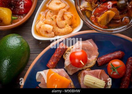 Démarreurs mixtes des tapas espagnoles sur table. Sandwichs ouverts, crevettes, légumes marinés. Vue d'en haut Banque D'Images