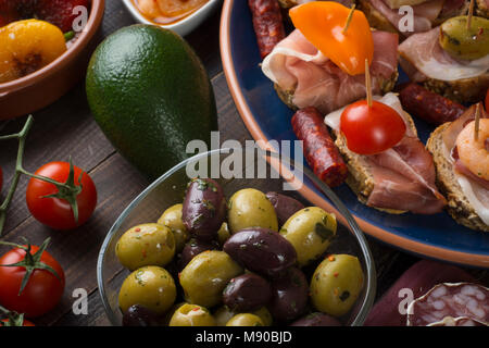 Tapas espagnol mixte partage avec entrées olives, salami saucisses et sandwichs sur vintage ancienne table. Vue d'en haut Banque D'Images