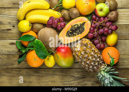 Variété de produits frais et Fruits de saison d'été Tropical Papaye Ananas Bananes noix de coco Mangue Kiwi Oranges Citrons pamplemousses sur fond de bois. En bonne santé Banque D'Images