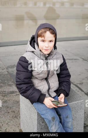 7 ans avec smartphone outdoors in winter Banque D'Images