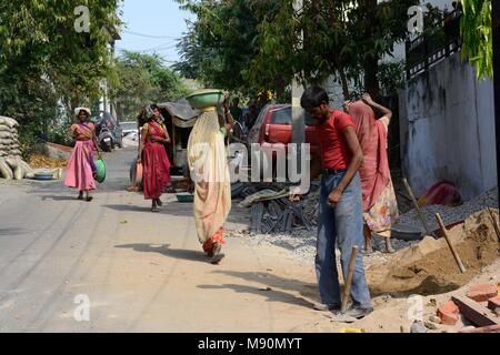 Les femmes indiennes portant des saris travaillant dans la construction la réalisation de bols de sable et de pierres sur leur tête pour faire le ciment pour la construction d'Udaipur Inde Rajashan Banque D'Images