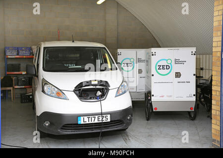 Une Nissan eNV200 fourgon électrique branché pour recharger dans un garage dans le nord de Londres, Royaume-Uni. Banque D'Images