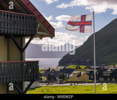 Drapeau des îles Féroé dans la brise au-dessus du village de Gjógv dans les îles Féroé, Danemark. En été (juin) 2017. Banque D'Images