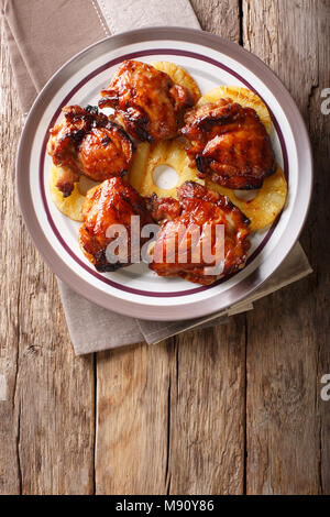 Barbecue hawaïen huli huli : vitrage poulet grillé à l'ananas sur une assiette. Haut Vertical Vue de dessus Banque D'Images