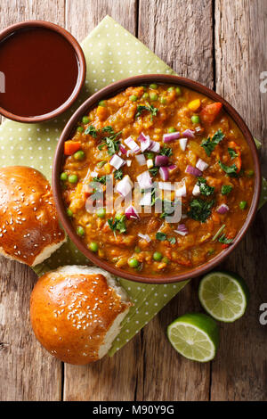 Pav Bhaji épicé indien restauration rapide avec du pain Paav close-up dans un bol sur la table. Haut Vertical Vue de dessus Banque D'Images