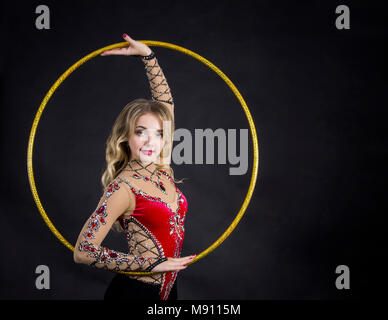 La femme contortionniste en costume de scène avec des paniers. Studio tourné sur fond sombre. Banque D'Images