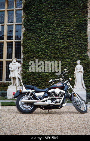 Moto Harley Davidson garée en face de Littlecote House, plus regardé par des statues de Henry les huit et Anne Boleyn, Berkshire, Angleterre le 30 septembre 1989 l'ion. La manifestation était organisée par Peter de Savary qui possédait la chambre à ce moment-là. Banque D'Images