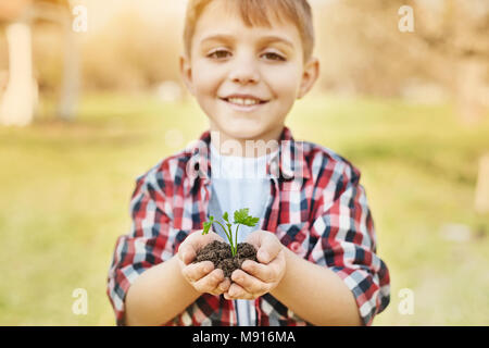 Little Boy holding positive dans les mains du sol Banque D'Images