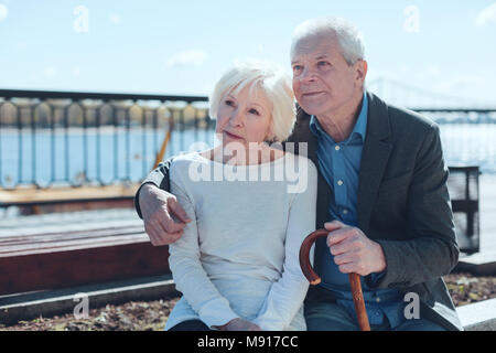 Pensive couple marié à rêver ensemble à l'extérieur Banque D'Images
