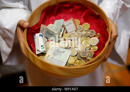 Au cours d'une Messe catholique Collection Panier avec d'Euros. Sallanches. La France. Banque D'Images