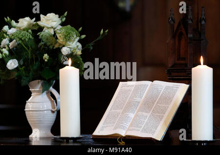 Les bougies et l'église bible ouverte sur un autel. Strasbourg. La France. Banque D'Images