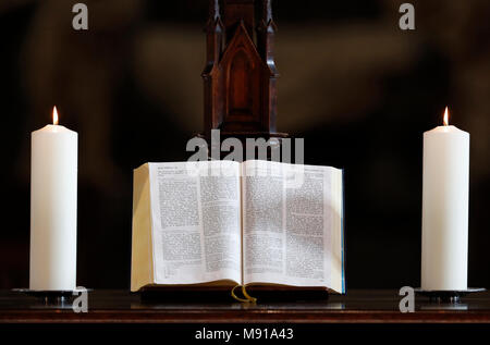 Les bougies et l'église bible ouverte sur un autel. Strasbourg. La France. Banque D'Images