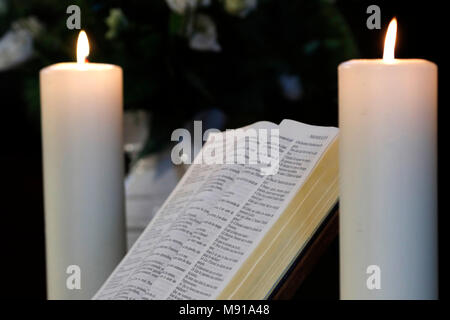 Les bougies et l'église bible ouverte sur un autel. Strasbourg. La France. Banque D'Images