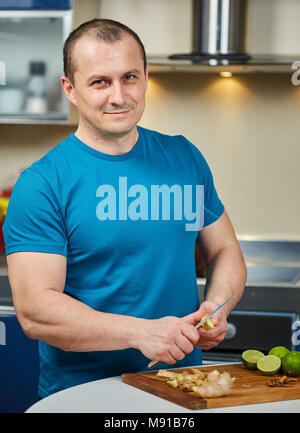 Man peeling ginger sur une planche en bois Banque D'Images