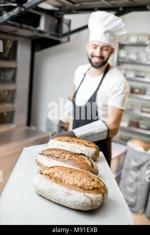 Baker avec pain frais à la boulangerie Banque D'Images