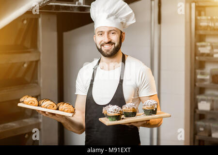 Pâtissier avec des pâtisseries dans la fabrication Banque D'Images