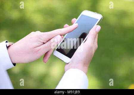 Femme à l'aide de smart mobile phone in park. Banque D'Images