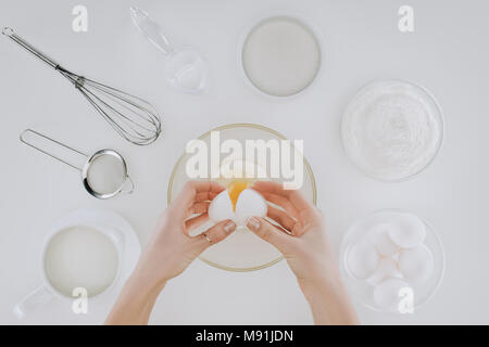 Cropped shot de personne tenant pendant la cuisson des oeufs isolés des crêpes sur gris Banque D'Images