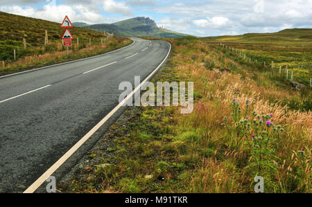 Plan large de la route vide, de courbe, de bosses et de réduire la vitesse maintenant signer avec Vieil Homme de Storr mountain en arrière-plan. Isle of Skye, Scotland, United Kingd Banque D'Images