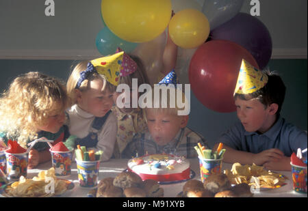 Une fête d'anniversaire pour enfants soufflant les bougies Banque D'Images