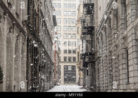 Allée de la rue du Vieux-Montréal en hiver sous une tempête de neige avec un gratte-ciel moderne à l'image de fond d'une petite allée dans la rue plus par Banque D'Images